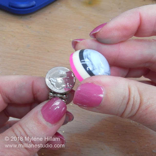 Placing the striped resin cabochon onto the adhesive on the ring blank