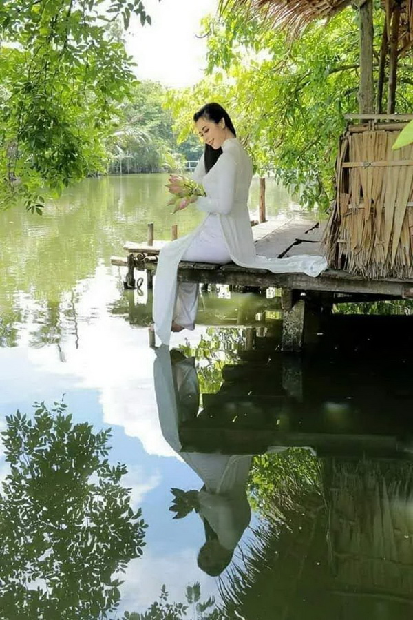 Thiếu nữ ngồi áo dài trắng, dòng sông