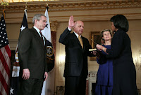 President George W. Bush looks on as Secretary of State Condoleezza Rice administers the oath of office to Deputy Secretary of State John Negroponte Tuesday, Feb. 27, 2007, in the Benjamin Franklin Room at the U.S. Department of State. Holding the Bible for the ceremonial swearing-in is Dr. Diana Negroponte, wife of Secretary Negroponte. White House photo by Paul Morse