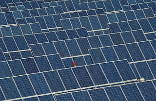 An employee walks between rows of solar panels at a solar power plant on the outskirts of Dunhuang, Gansu province, China, June 10, 2011. (Credit: Reuters/Stringer/File Photo) Click to Enlarge.