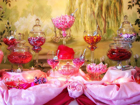  couples are choosing a table full of sweets for their wedding reception