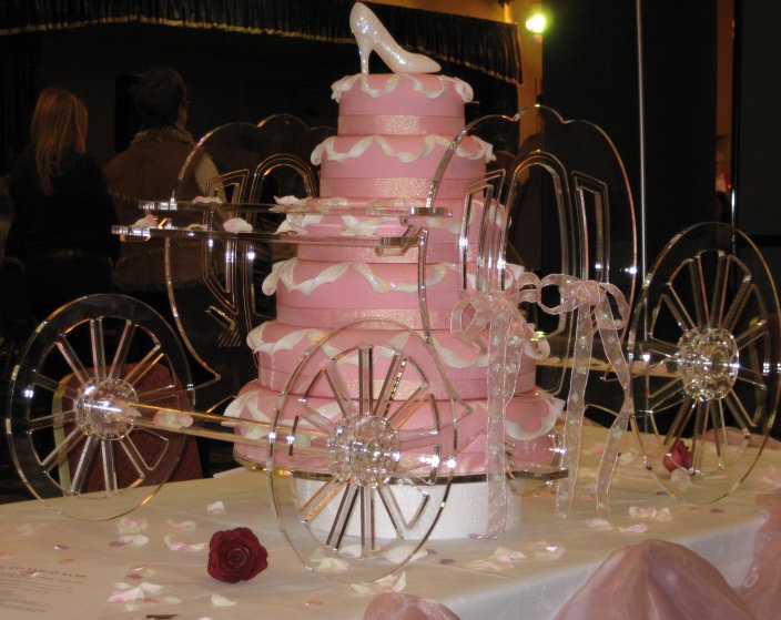 Six tier Cinderella's carriage wedding cake in pink with glass carriage and