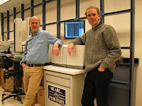 Penn State genomicists Webb Miller and Stephan C. Schuster in front of the Roche/454 Life Sciences' Genome Sequencer 20 System that was used to sequence mammoth DNA. Credit: Penn State University.
