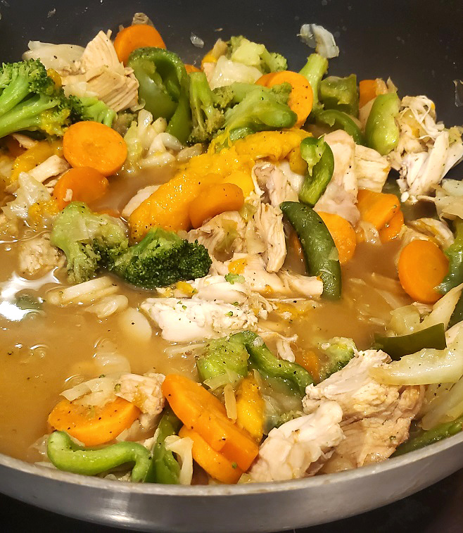 mango and chicken in a pan of frozen stir fry vegetables