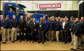 Kenworth employees stand with the first production Kenworth W990