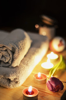 Two towels, candles and a rose at a Mykonos spa space.