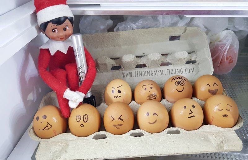 elf drawing faces on eggs