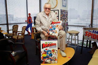 Stan Lee holding 75 Years of Marvel Comics: From the Golden Age to the Silver Screen hardcover book by Roy Thomas and Josh Baker