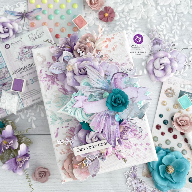 Mixed media canvas featuring a hummingbird and paper flowers from the Prima Marketing The 3 Girls Tale collections Lost in Wonderland, Postcards from Paradise and Aquarelle Dreams.