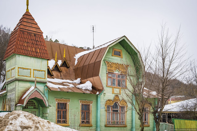 Зеленая деревянная усадьба с башенкой