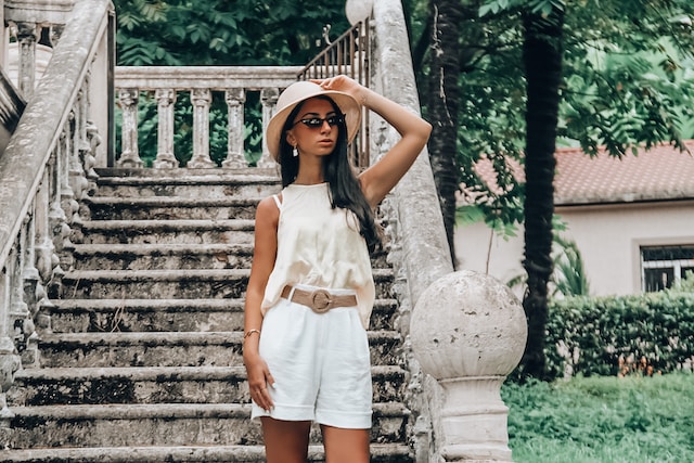 Lady wearing shorts, a hat, and sunglasses