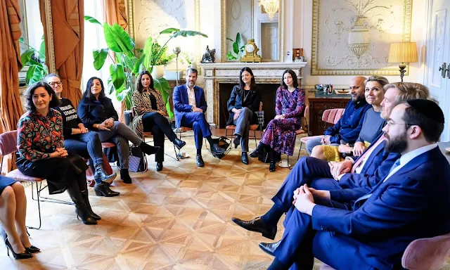 Queen Maxima wore a yellow lace skirt by Natan and navy blue top by Natan, and a grey cashmere cape by Natan. Mayor Femke Halsema