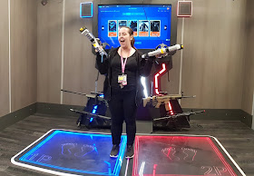 x gen VR manager Lily with both guns in hand demonstrating 2 player shooting VR game