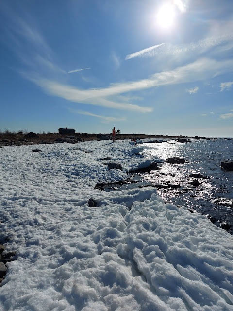 Lunta meren rannalla, aurinko paistaa