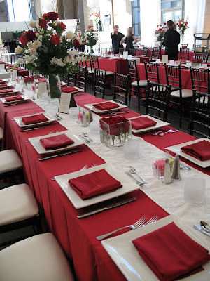 Tall arrangements of red and white flowers sat on top of tall cube vases