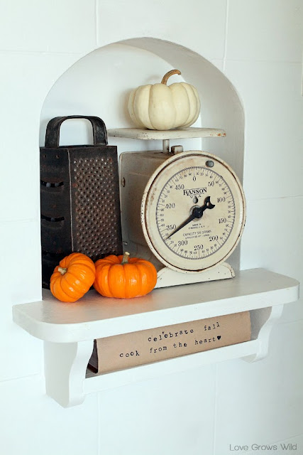 A kitchen beautifully decorated for Fall with sheet music garlands, mini pallet art, and more!