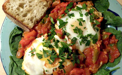 Shakshuka served over spinach with bread