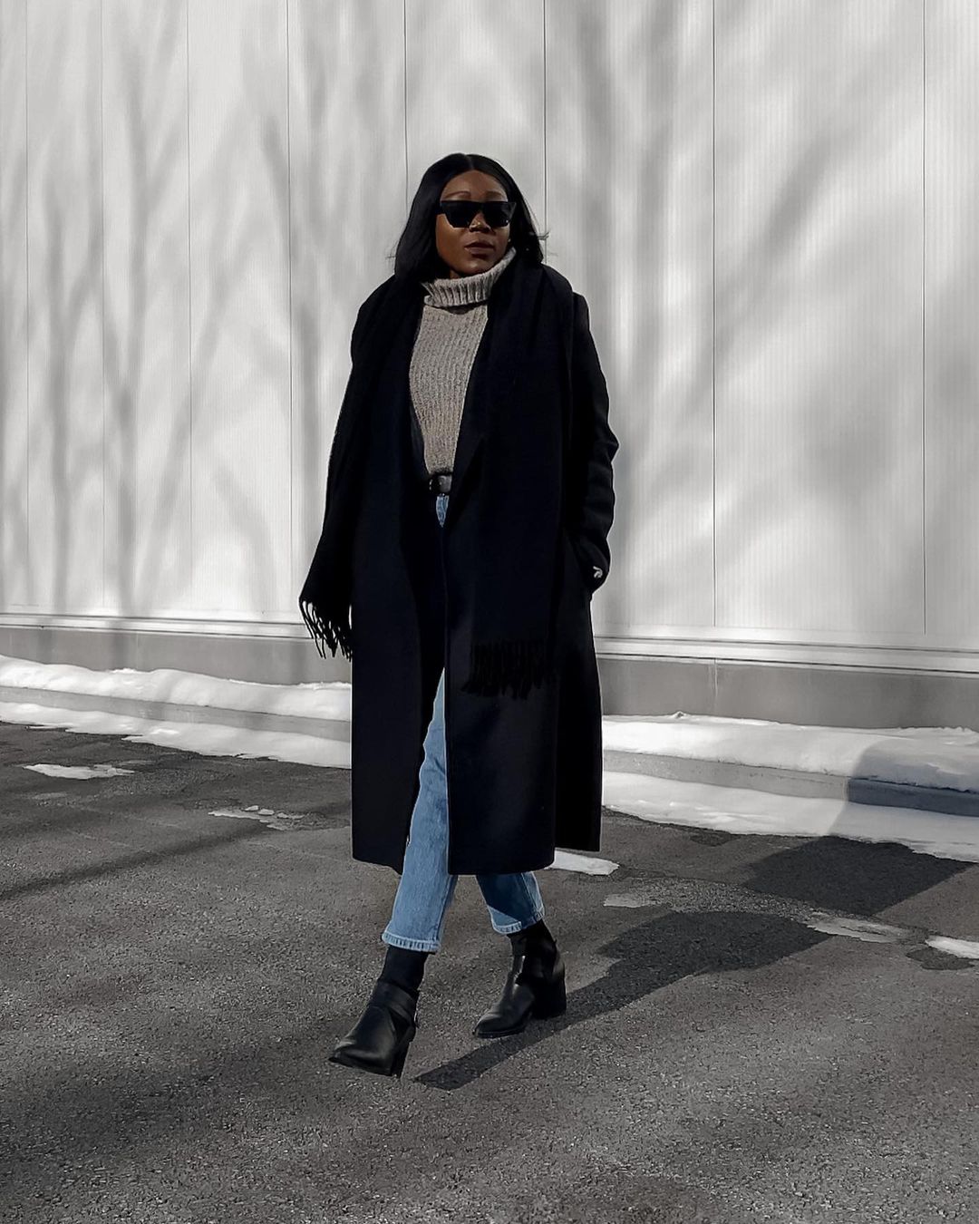 Stylish Winter Outfit Idea From Instagram — Sabrinah Edouard in a black coat, gray turtleneck sweater, jeans, and black boots