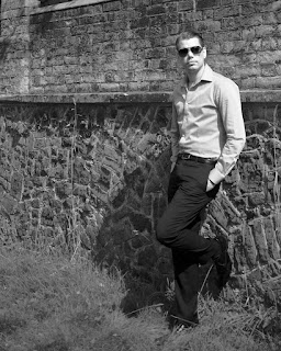 shirt and trousers leaning against a wall black and white