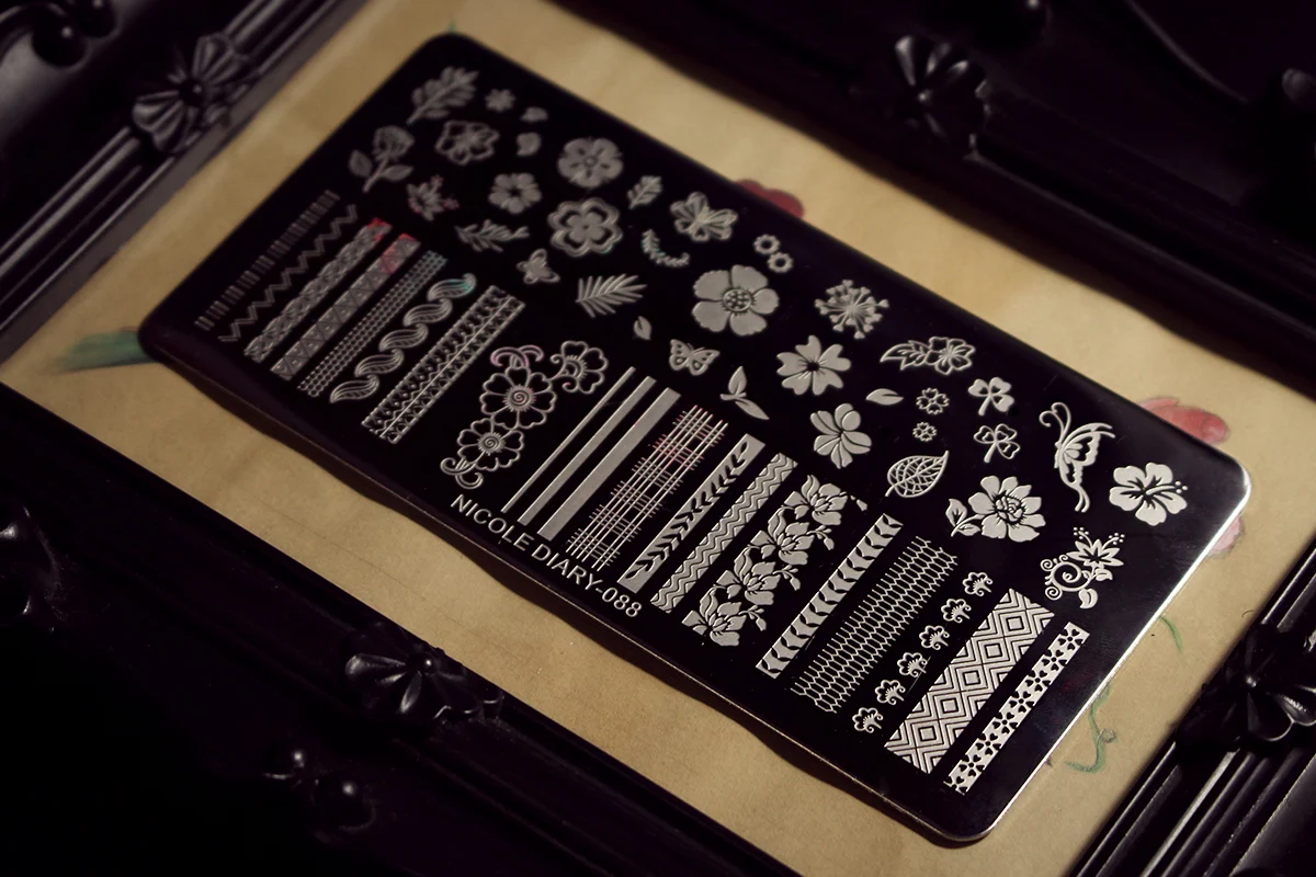 an aesthetic close-up of a stainless steel nail stamping plate with spooky halloween pattern