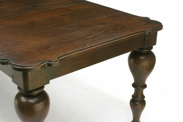 solid oak extension dining table with antique walnut finish has dramatic turned legs