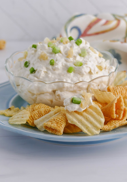 dip in a clear bowl on a blue plate with a light background.