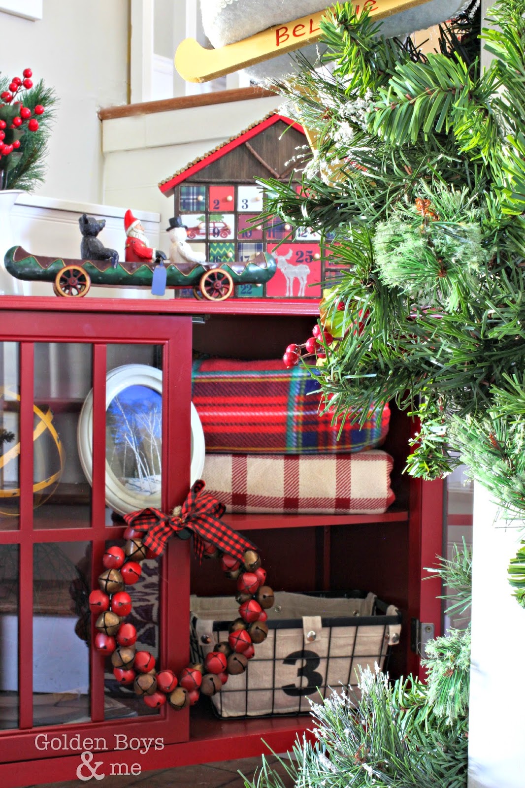 Target red windham bookcase with plaid blankets in rustic Christmas entryway-www.goldenboysandme.com
