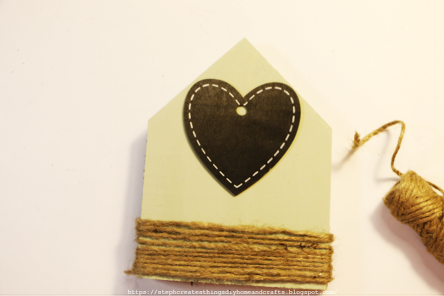 Wooden house plaque with twine and heart embellishment