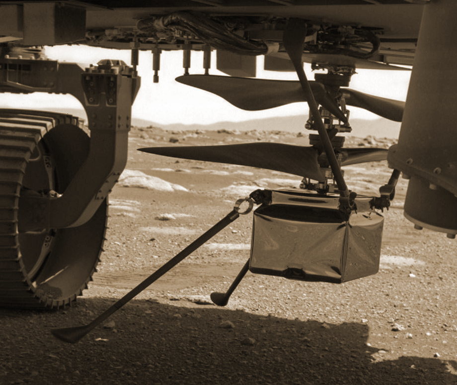 Ingenuity’s 2 legs tip-toeing close to the ground under the rover. NASA/JPL, Mars, sol 38, 2021.