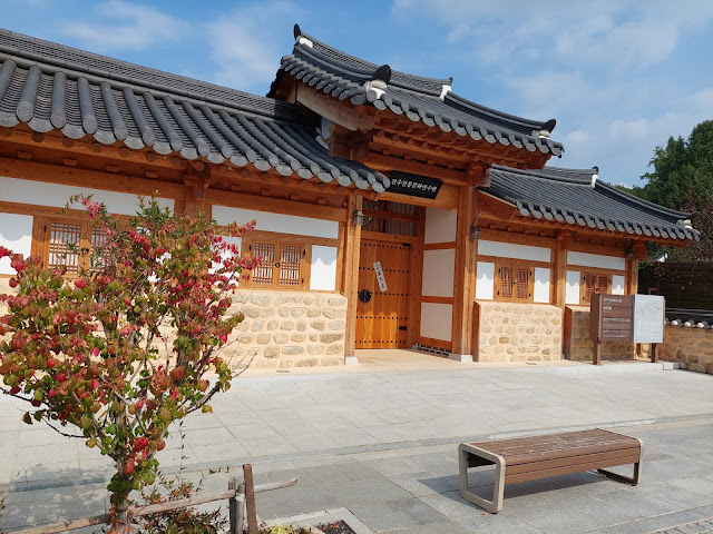 Traditional hanok house and walls, the typical entrance of an old facitly in geonju south korea. The lanterns and the trees in front of hanok house are impressive.