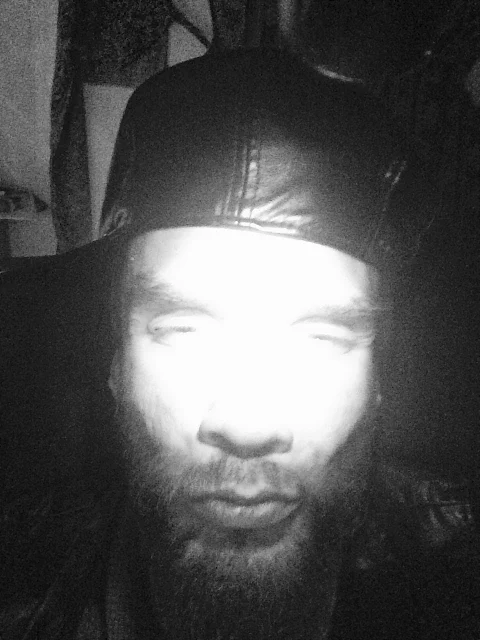 11 Black and white photograph of OregonLeatherBoys had only wearing a black leather hat and bright light shining in face being brainjacked