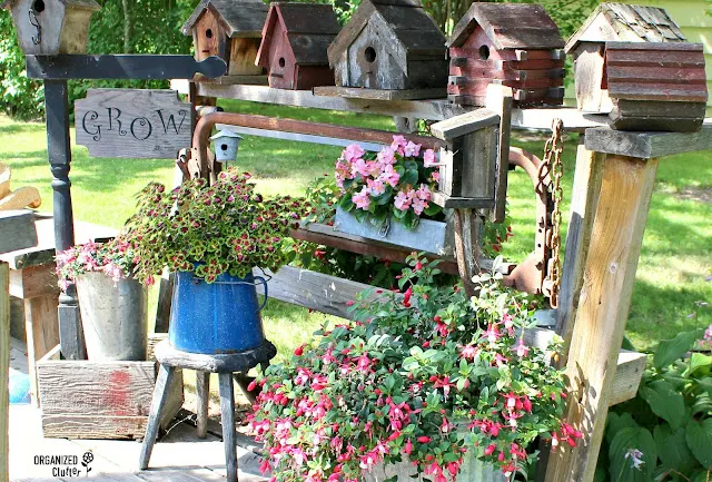 Photo of a rustic birdhouse junk garden vignette.