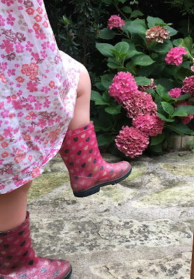 deux bottes d'enfant en mouvement devant l'hortensia