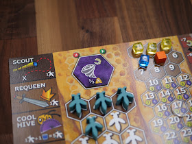 The Bee Lives board with bee meeples on it, including the hexagons they land in and signs for swarming, scouting, requeening, and "cool hive"