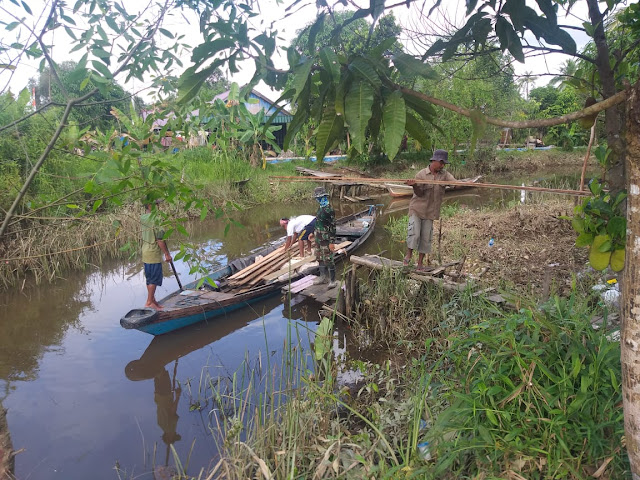 Satgas dan Warga Turunkan Papan Dari Perahu Kayu Figur News Satgas dan Warga Turunkan Papan Dari Perahu Kayu Figur News