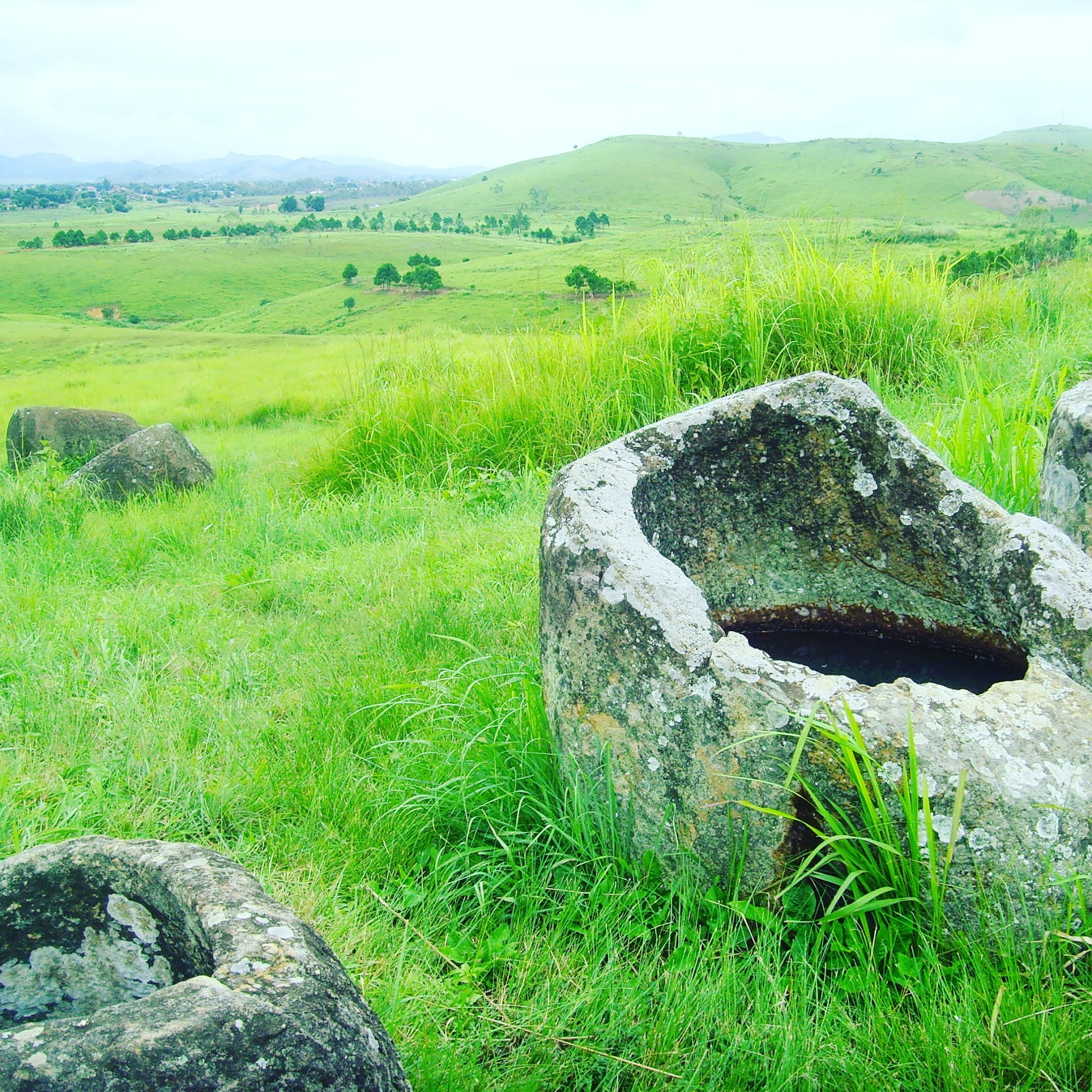 large stone jar in field in phonsavan laos surrounded by grass