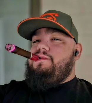 Looking proud and sexy with the cigar mouth nice beard wearing green cap