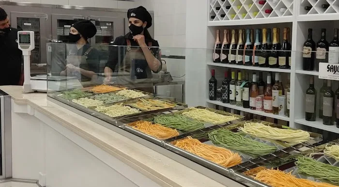 Imagen de personas atendiendo en una fabrica de pastas