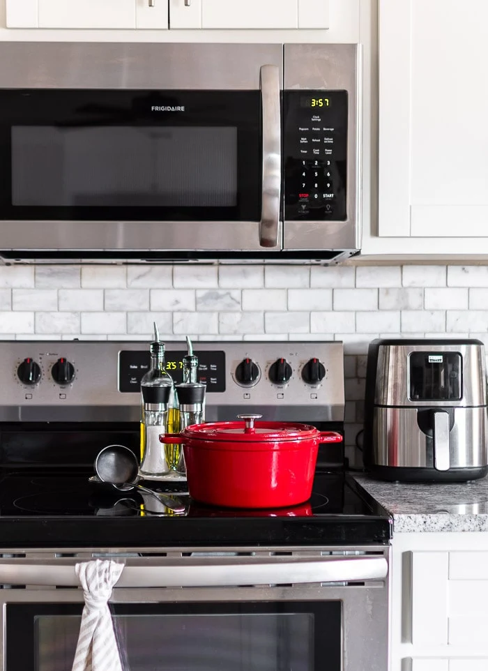 stovetop, red Dutch oven, striped towel