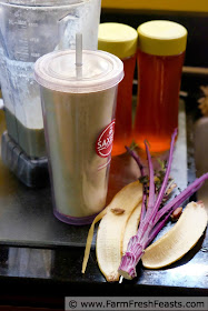 a side view of a banana, peanut butter, and date smoothie with curly kale