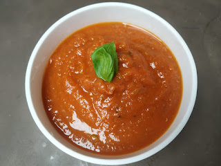 red sauce for pasta in a bowl topping with basil