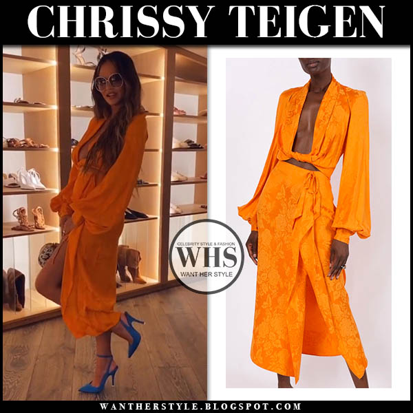Chrissy Teigen in orange blouse and skirt