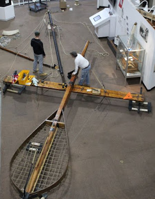 Overhead view of iceboat backbone and car, which looks like a giant badminton racket. At a right angle across the backbone is the runner plank, which has a "skate" at each end to balance the boat and help it move on the ice.