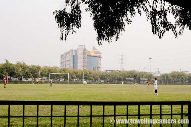 Noida is one of the top revenue generating city for Uttar Pradesh state of India and is mainly known as one of the software hubs in India !!! In the middle of Noida city, there is a Sports stadium for residents of city and really popular among children !!!My office is near to Noida Stadium and it comes on the way from my house to office... Two years back, an area of this stadium was developed for golf lovers... It's just in front main gate and can be seen by everyone crossing through road touching SPICE mall and Adobe India office...There is a wonderful football ground inside Noida Stadium.... Coaches for various sports are available at Noida Stadium and school children come here during early mornings & evenings... People from surrounding sectors like 21, 25 and 26 come for jogging...Tennis, basketball and squash are also available... There are different models to get entry to Noida stadium. It seems, there is some long term membership where some amount needs to be submitted for an year or so. For that you get access to various parts of the stadium and mentors can be identifies for improving your skills... Other way is to get membership for a month or so... One of my friend used to go there and he was only allowed to access badminton ground for one hour a day ! Stadium is very well maintained and recently I have heard that huge amount is approved by UP government for improving facilities at Noida Stadium... Annual Flower Fair of Noida takes place at this stadium only !!All grounds for various sports are well connected with roads and parking areas are there in surroundings... There are appropriate jogging paths at Noida Stadium !!Noida Stadium is adjacent to jalvahu vihar, Sector 21, 25,22, spice mall and city center. The sectors you see behind this ground are in sector 21...Honda City parked in parking area of Noida Stadium !! And the building behind if Adobe Systems India... The most colorful and beautiful building in Noida City... This is back side of the building which is black and grey... Front part is really colorful and has wonderful colors...