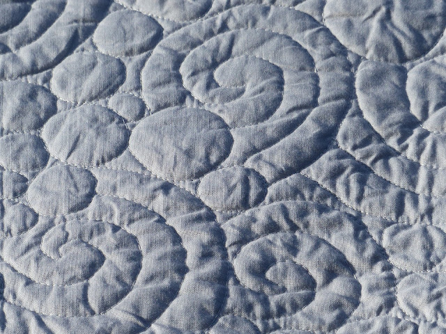 Close up view of a swirl and pebble quilting motif
