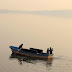 A couple takes a selfie while riding on a boat at the Rawal Lake