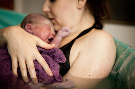 mom holding her baby after giving birth photo