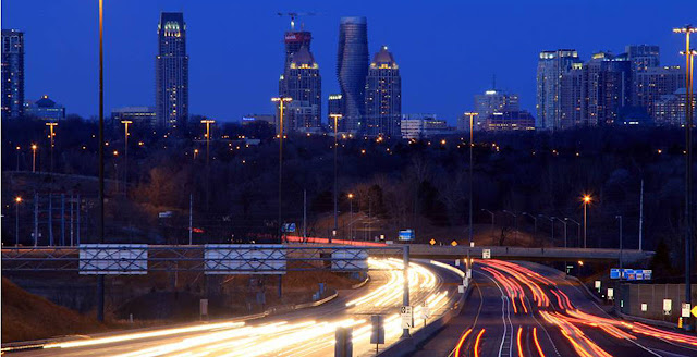 Photo of towers under construction at sunset as seen from the highway