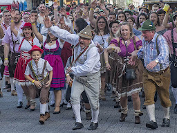A crowd of people in a German festival enthusiastically having a good time together