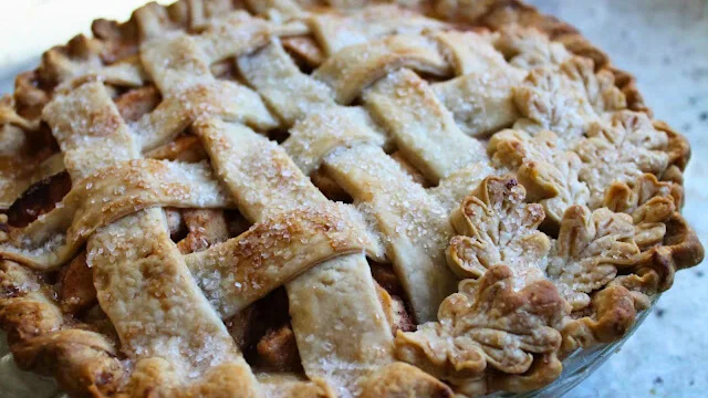 An apple pie with a lattice crust and leaf embellishments.